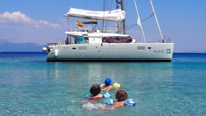 Escuela náutica de Avante: Aguas cristalinas con niñas nadando hacia catamarán fondeado- Curso PER