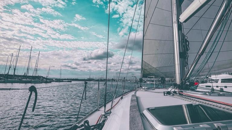 Velero entrando a puerto con un cielo empedrado