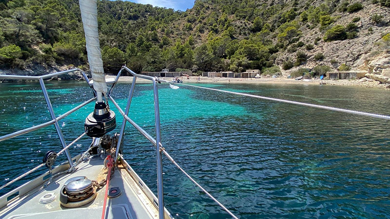 Un velero navega cerca de la playa.