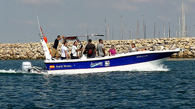 Grupo de personas en un barco en el agua durante prácticas de PER, PNB y Licencia de navegación.