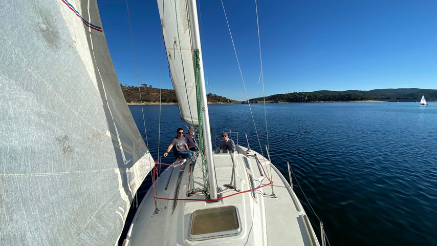 Prácticas de navegación a vela: desde la proa del velero se ven el cielo y el agua azules en practicas de vela en Madrid