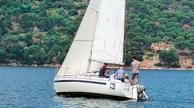 Velero navegando en aguas tranquilas del pantano de San Juan Madrid