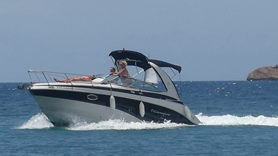 Lancha navegando en el mar con un pasajero en la parte posterior.