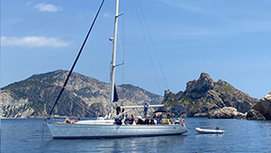 grupo de amigos en velero arrastrando una zodiac para acercarse a calas