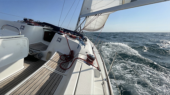 Vista frontal de un velero navegando en el mar durante prácticas de vela