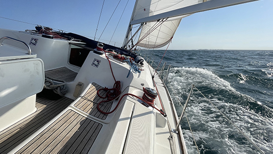 Vista frontal de un velero navegando en el mar durante prácticas de vela