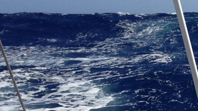 Un velero en el océano con olas chocando contra él.