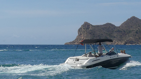 Barco navegando en el mar con calas de fondo